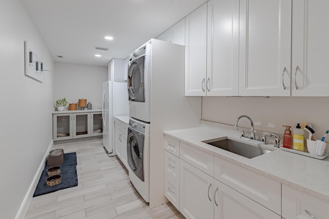 8005 SW Yachtsmans Dr, Stuart, FL 34997 - laundry area featuring stacked washer and clothes dryer, baseboards, recessed lighting, and light wood-style floors