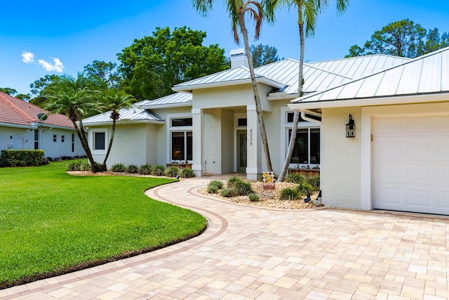 8005 SW Yachtsmans Dr, Stuart, FL 34997 - view of front of house with a standing seam roof, metal roof, stucco siding, and decorative driveway