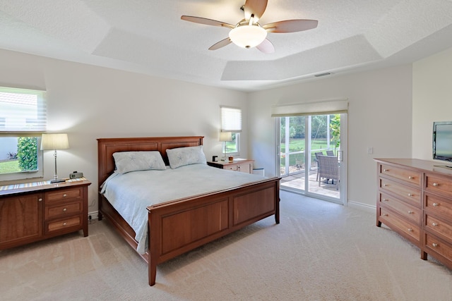 8005 SW Yachtsmans Dr, Stuart, FL 34997 - bedroom featuring light colored carpet, access to exterior, a raised ceiling, a ceiling fan, and baseboards