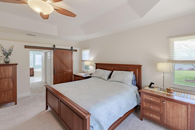 8005 SW Yachtsmans Dr, Stuart, FL 34997 - bedroom featuring light carpet, a barn door, a tray ceiling, a ceiling fan, and baseboards