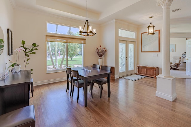 8005 SW Yachtsmans Dr, Stuart, FL 34997 - dining room with ornate columns, wood finished floors, a tray ceiling, a chandelier, and crown molding