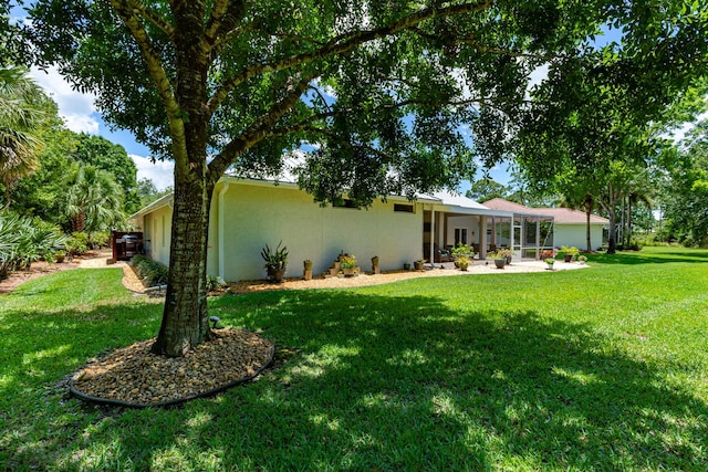 8005 SW Yachtsmans Dr, Stuart, FL 34997 - rear view of house featuring stucco siding, a yard, and a sunroom
