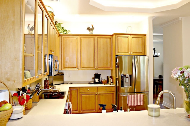 kitchen featuring appliances with stainless steel finishes, glass insert cabinets, light countertops, and a tray ceiling