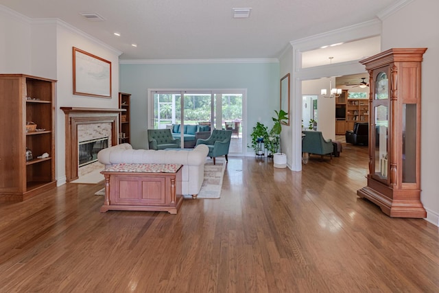 8005 SW Yachtsmans Dr, Stuart, FL 34997 - living room with a high end fireplace, wood finished floors, crown molding, a chandelier, and baseboards