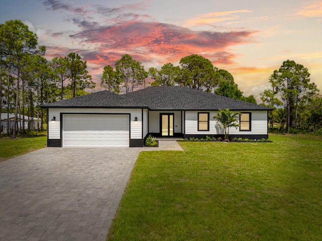 17816 86th St N, The Acreage, FL 33470 - view of front of house featuring french doors, an attached garage, decorative driveway, and a front yard