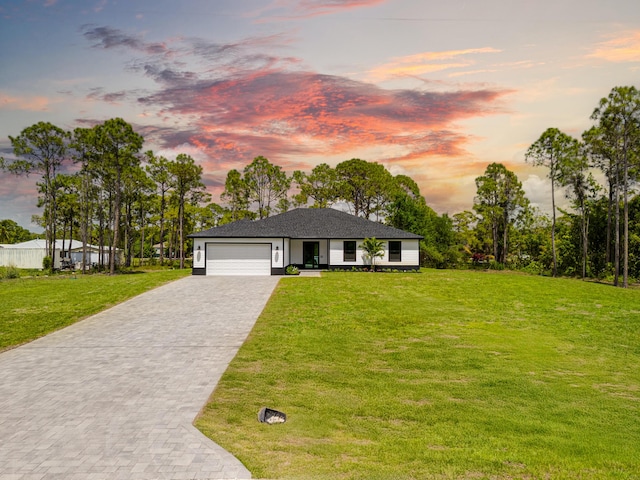 17816 86th St N, The Acreage, FL 33470 - view of front of house with an attached garage, a yard, and decorative driveway