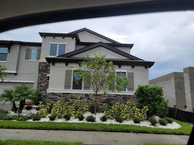 exterior space with stone siding and stucco siding