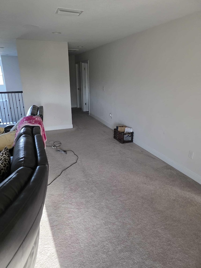 unfurnished living room with baseboards, carpet floors, and visible vents