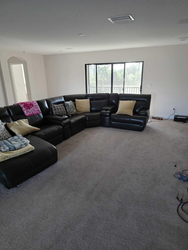 living room featuring carpet floors, arched walkways, and visible vents