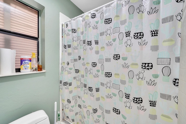 bathroom with toilet and curtained shower