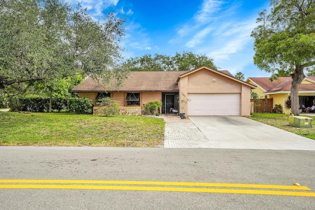 ranch-style home with a garage, stucco siding, driveway, and a front yard
