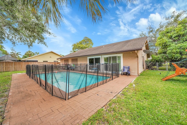 view of swimming pool with a lawn, a fenced in pool, a fenced backyard, and a patio