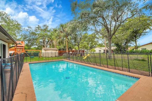 view of pool featuring a playground, a fenced in pool, a yard, and a fenced backyard