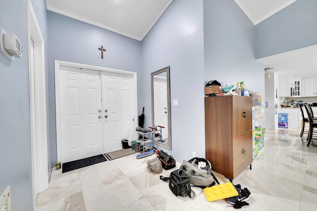 entrance foyer featuring high vaulted ceiling and ornamental molding
