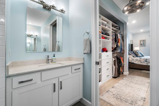 1220 Haywagon Trl, The Acreage, FL 33470 - bathroom featuring baseboards, a spacious closet, vanity, and wood finished floors
