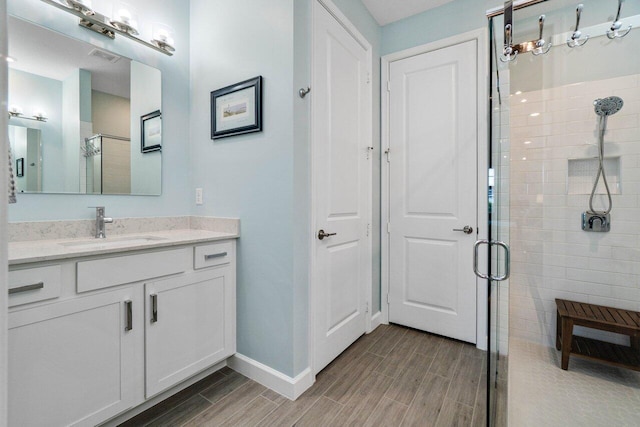 1220 Haywagon Trl, The Acreage, FL 33470 - full bathroom with baseboards, visible vents, a shower stall, vanity, and wood finish floors