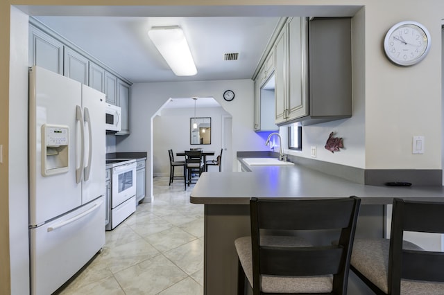 185 Bilbao St, Royal Palm Beach, FL 33411 - kitchen with visible vents, arched walkways, a sink, a peninsula, and white appliances