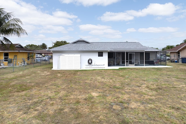 185 Bilbao St, Royal Palm Beach, FL 33411 - back of house featuring a lawn, a shingled roof, fence, and a sunroom