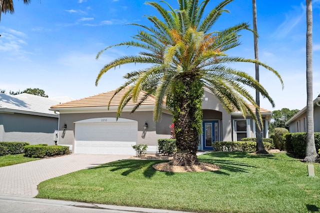doorway to property with an attached garage, a lawn, stucco siding, and a tile roof