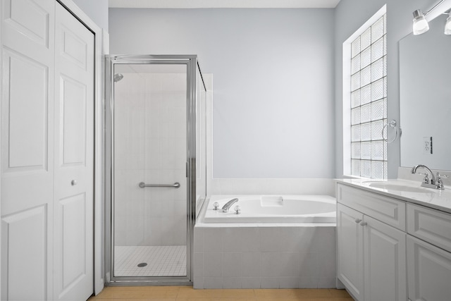 full bathroom featuring a bath, a stall shower, vanity, and tile patterned flooring