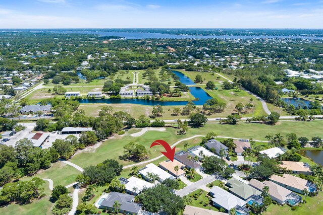 aerial view of property and surrounding area with a golf club, a large body of water, and nearby suburban area