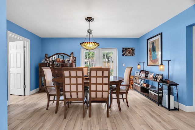 dining area with light wood finished floors and baseboards
