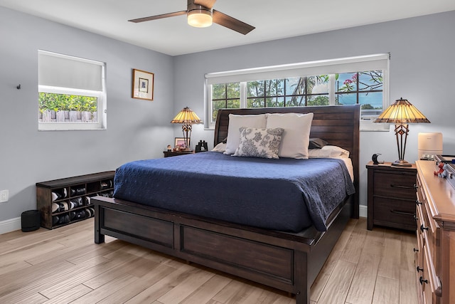 bedroom with baseboards, light wood-style flooring, and a ceiling fan
