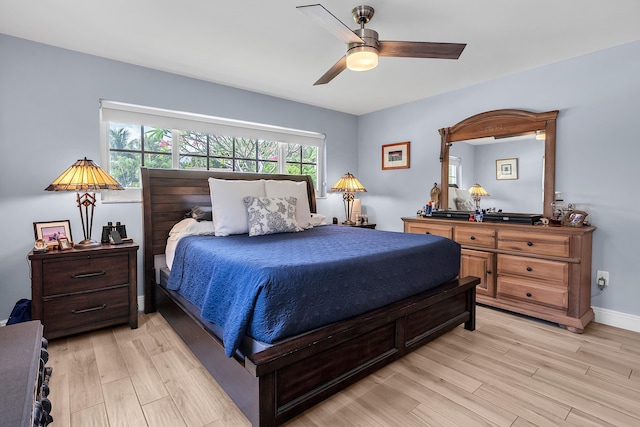 bedroom with light wood finished floors, baseboards, and ceiling fan