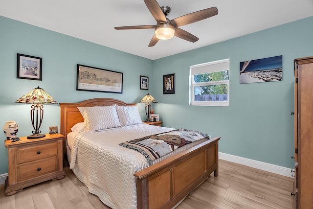bedroom with light wood-style floors, baseboards, and ceiling fan
