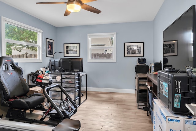 office space featuring light wood finished floors, baseboards, and a ceiling fan