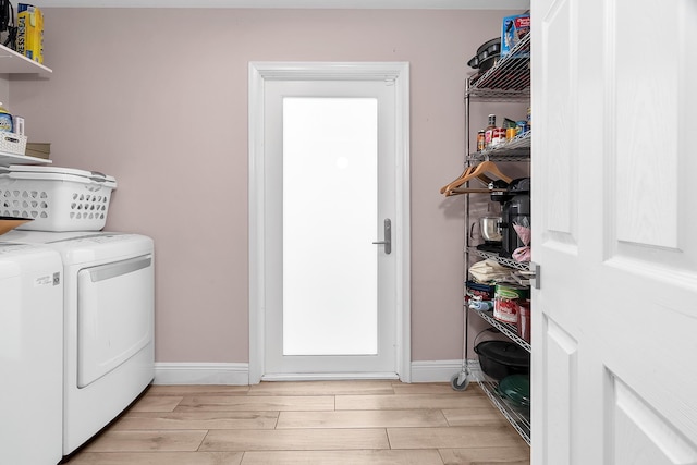 laundry area featuring washing machine and dryer, laundry area, baseboards, and light wood-style floors