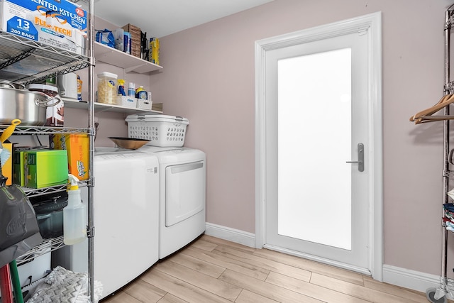 laundry area with separate washer and dryer, laundry area, light wood-style floors, and baseboards