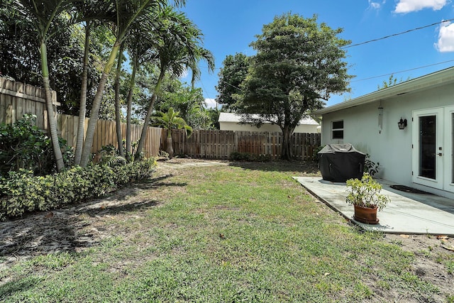 view of yard with a fenced backyard, a patio area, and french doors