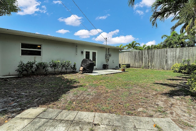 view of yard featuring a patio, french doors, and fence