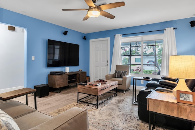 living room with light wood-style floors, baseboards, and ceiling fan