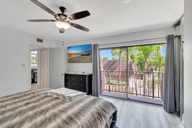 bedroom featuring access to outside, a ceiling fan, and a textured ceiling