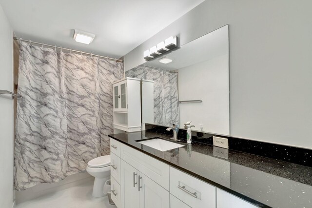 bathroom featuring toilet, vanity, and a shower with shower curtain