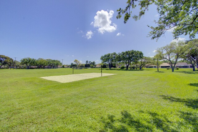view of property's community with volleyball court and a yard