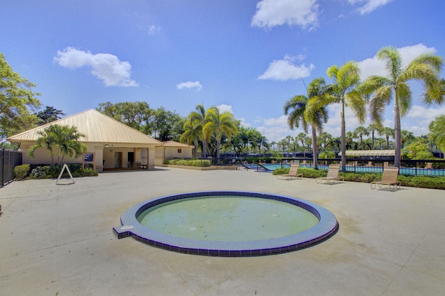 view of swimming pool with a pool, fence, and a patio