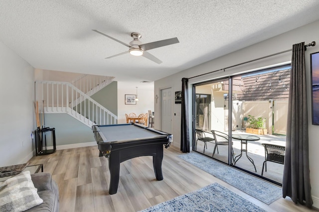 game room with light wood finished floors, a textured ceiling, pool table, ceiling fan, and baseboards