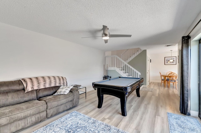 rec room with billiards, a ceiling fan, light wood-style floors, a textured ceiling, and baseboards