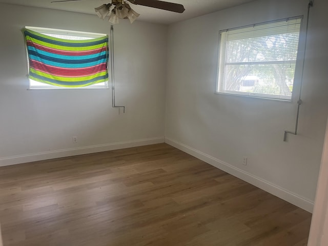 empty room featuring baseboards, ceiling fan, and wood finished floors