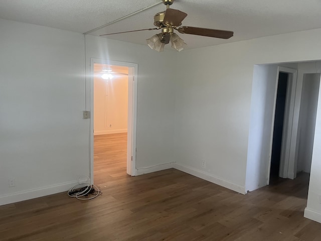 spare room with baseboards, ceiling fan, and wood finished floors