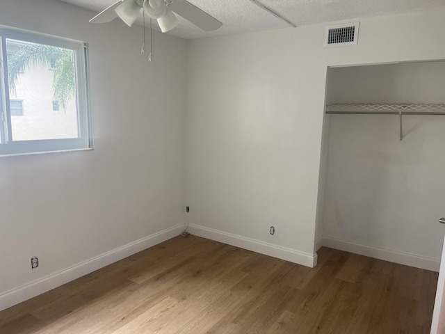 unfurnished bedroom featuring baseboards, visible vents, light wood-style flooring, and a closet