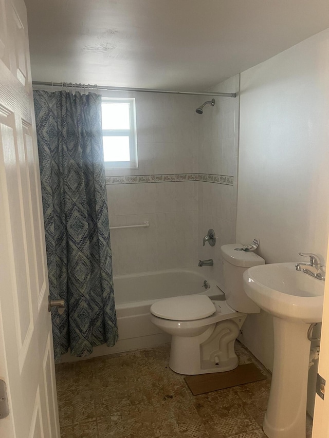 full bath featuring a sink, shower / tub combo, and toilet
