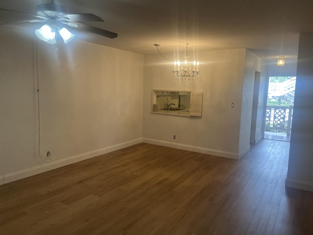 interior space featuring baseboards, wood finished floors, and ceiling fan with notable chandelier