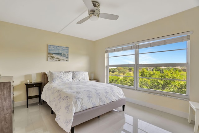 bedroom featuring light tile patterned floors, baseboards, and ceiling fan