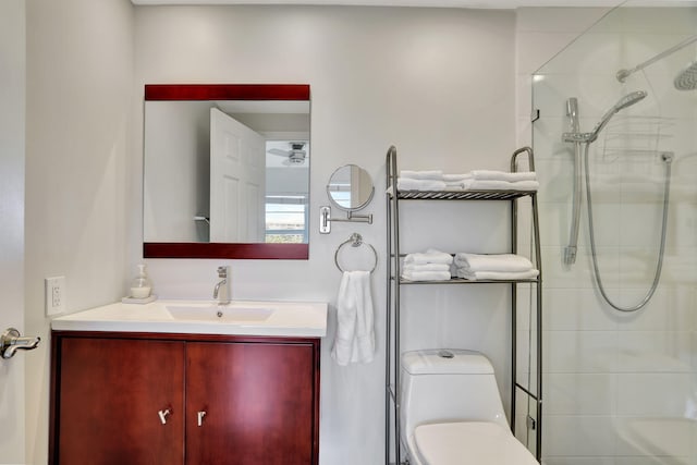 bathroom featuring vanity, toilet, and tiled shower