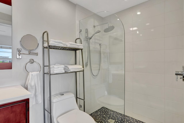 bathroom featuring a walk in shower, toilet, and vanity