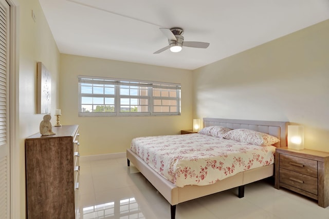 tiled bedroom with baseboards and ceiling fan